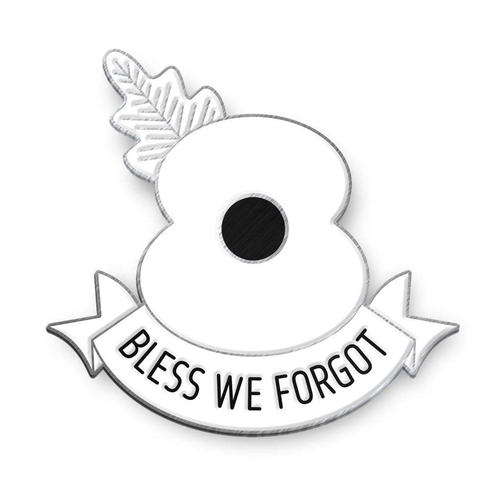 Enamel badge of a white poppy with a banner reading 'Bless We Forgot' on a white background with antique silver finish 
