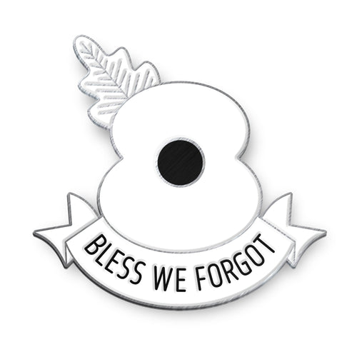 Enamel badge of a white poppy with a banner reading 'Bless We Forgot' on a white background with antique silver finish 