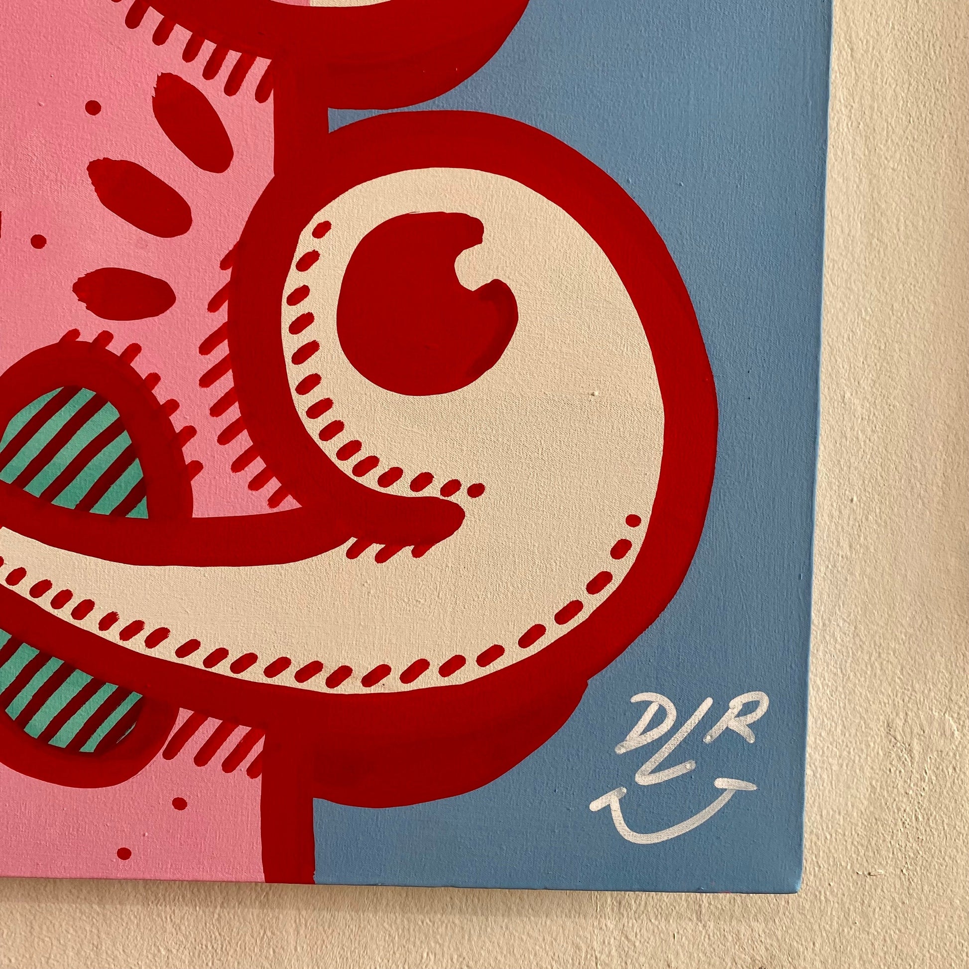 Abstract artwork with red, pink, and blue colors with the signature of the artist 
